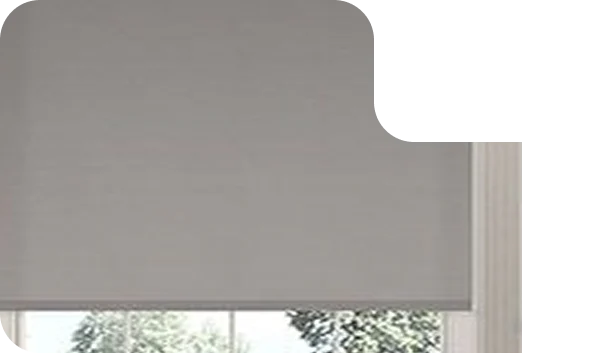 Grey blackout roller blind covering a window partially in a modern room