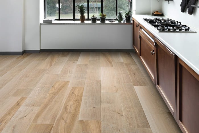 Contemporary kitchen space with matte light wood flooring and sleek cabinets.
