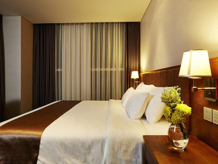 Twin beds in a bright room with sheer curtains and minimalist design