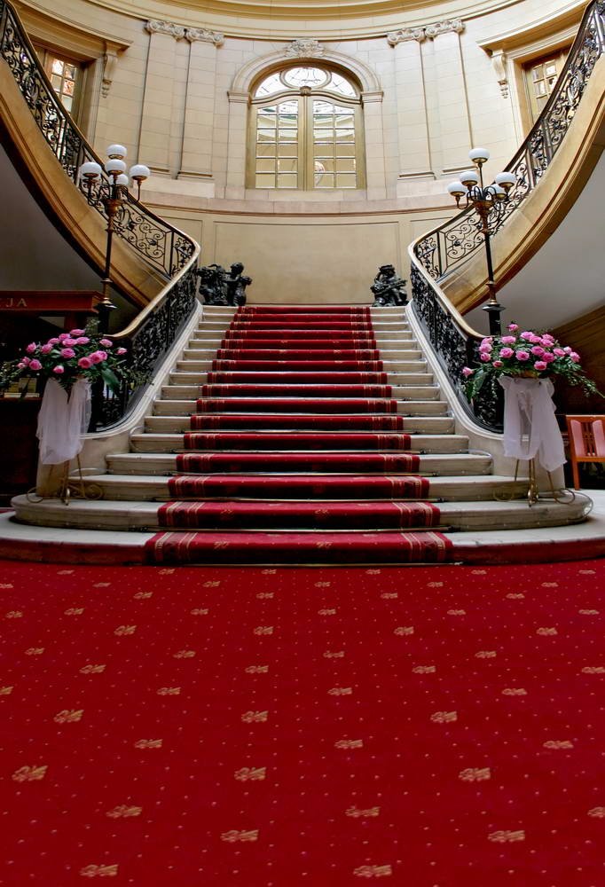 Ornate staircase with red carpet in a regal interior