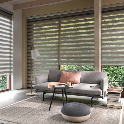 Brown zebra blinds in a living room with leather furniture