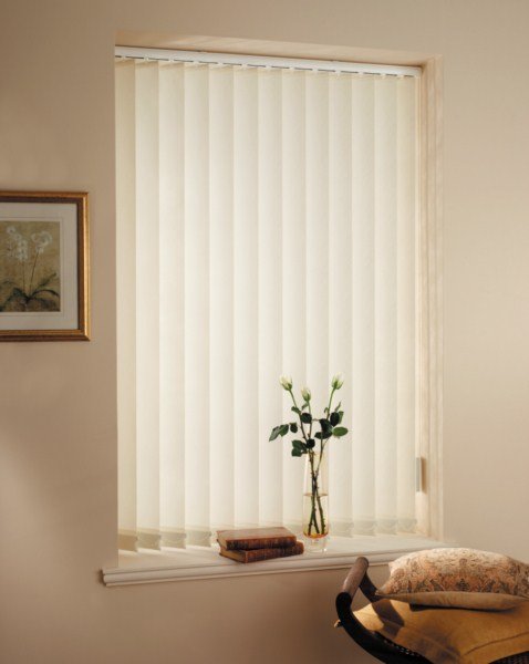 Stylish white vertical blinds covering sliding glass doors in a Dubai living room.