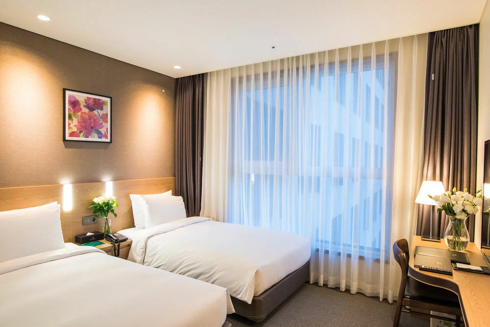 Elegant double bed with wooden headboard and bedside lamps