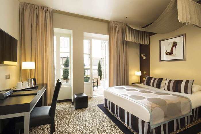 Hotel room with double bed, wall art, and warm lighting