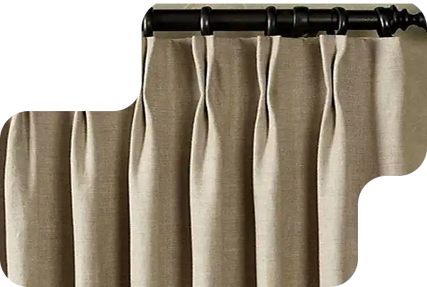 Close-up of beige pinch pleat curtains hanging on a dark decorative curtain rod.