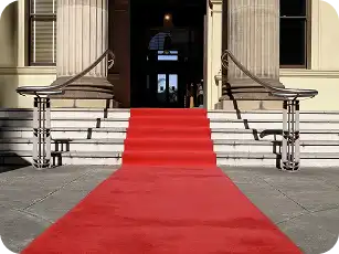 Red carpet laid on stone steps outside a building entrance