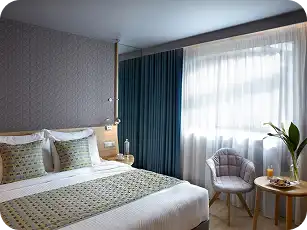 Modern hotel room with teal blackout curtains and sheer white drapes