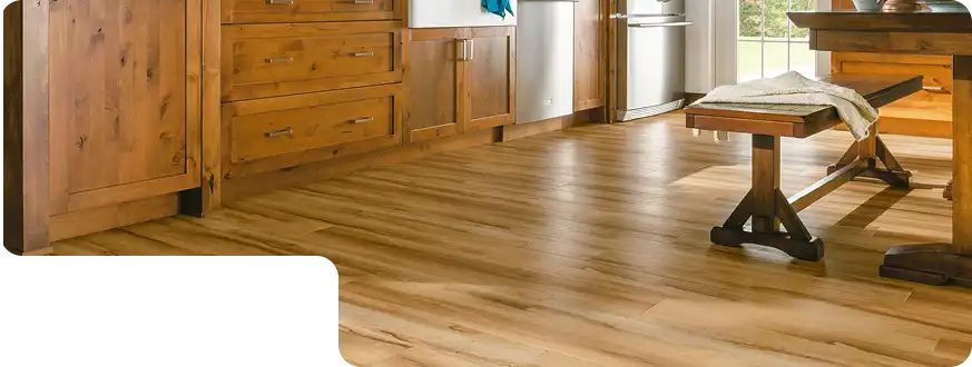Rustic kitchen and dining space with natural wood-look PVC flooring and wooden cabinetry.