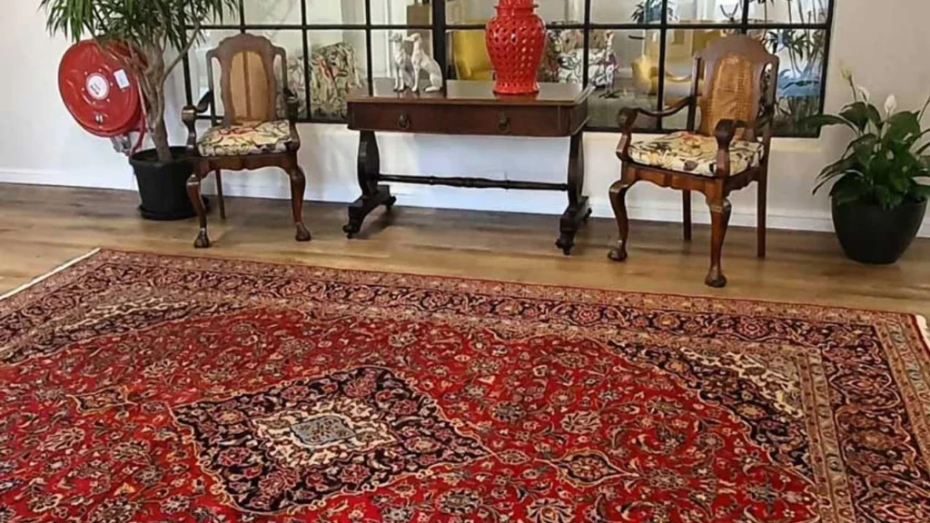 Authentic Persian rug in deep red with elegant floral border, enhancing cozy interiors.