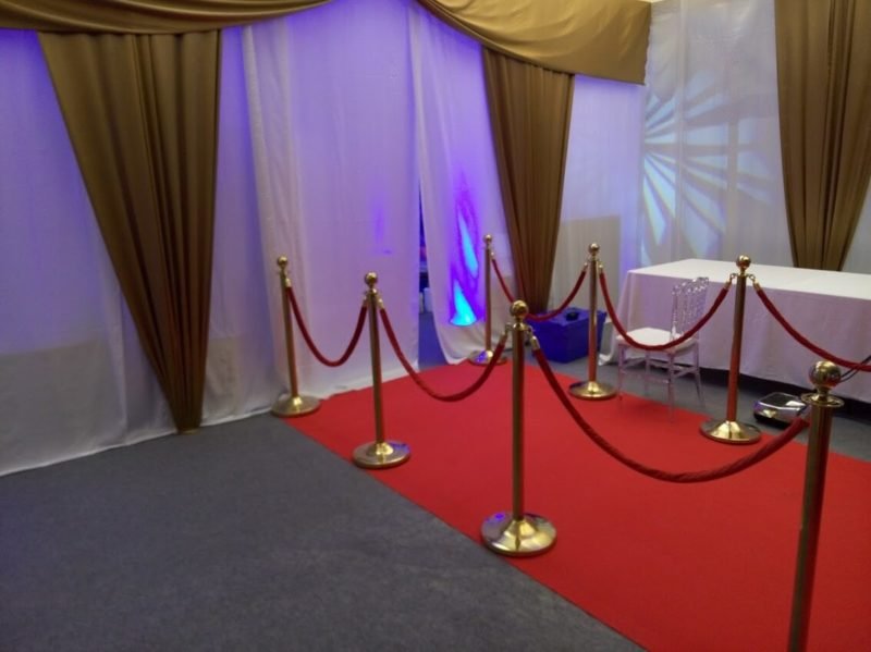 Red carpet outside a glass door entrance to an event venue