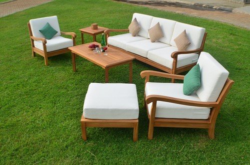 Modern outdoor sofa set with wooden frame and white cushions on green lawn