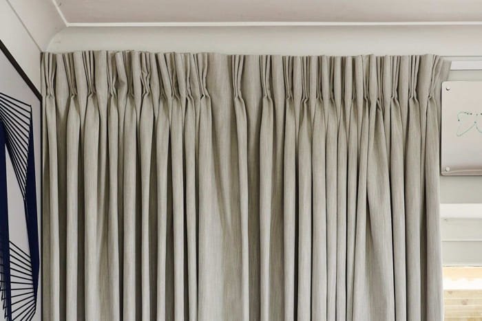 Beige pleated blackout curtains in a modern living room.