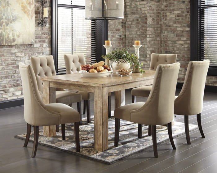 Elegant rectangular glass dining table with cream tufted chairs and metallic base.