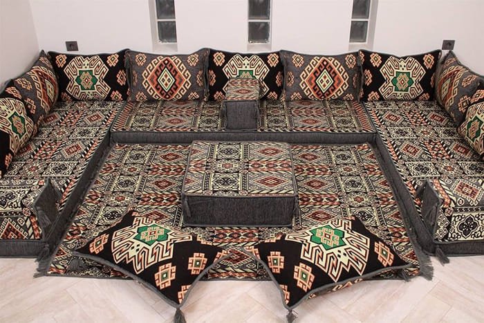 Ornate traditional majlis with richly patterned carpets and cushions