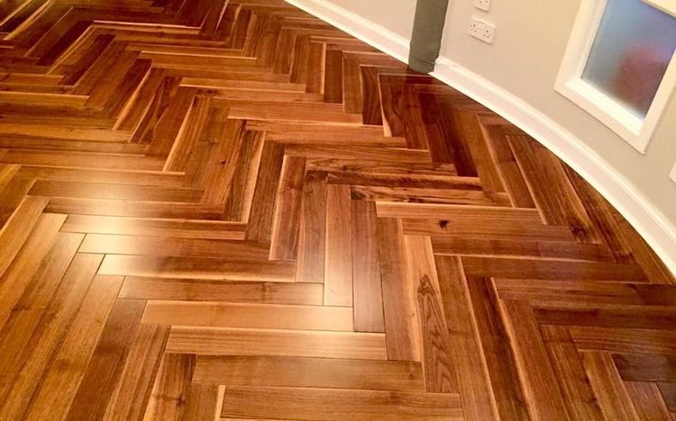 Elegant premium herringbone wooden flooring in a luxury Dubai bedroom with warm lighting and stylish décor.