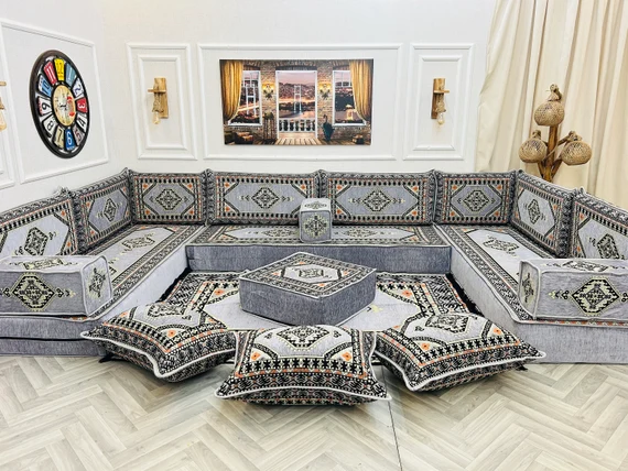Traditional Arabic majlis with silver and black seating and white tiled flooring