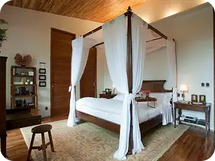 Luxurious king size canopy bed with upholstered headboard.