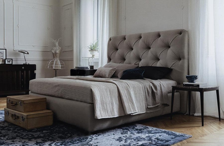 Luxury upholstered bed in grey fabric with padded headboard for comfort.