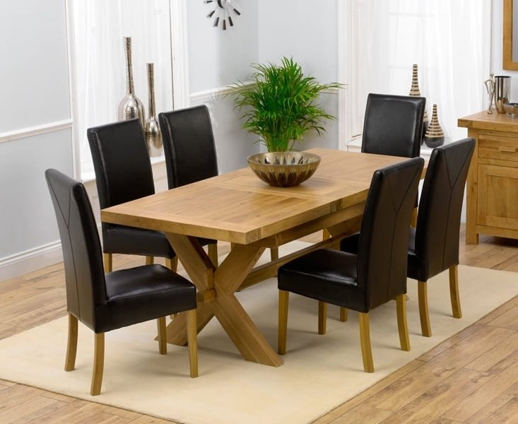 Wooden rectangular dining table with black and beige upholstered chairs.