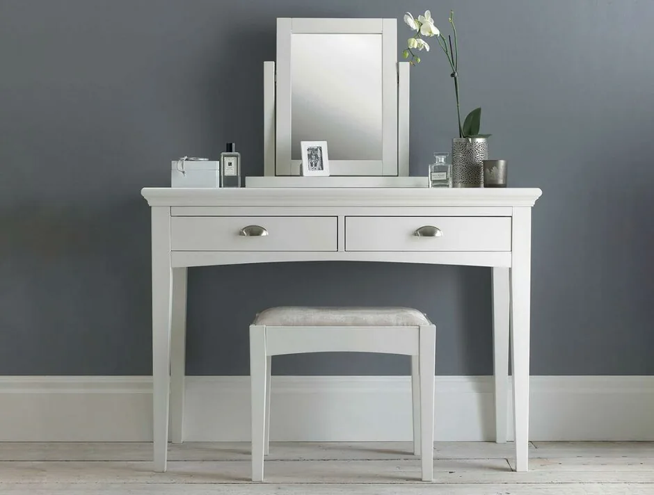 Minimalist white dressing table with rectangular mirror and matching stool.