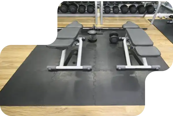 Durable black gym mats placed in a weightlifting area to protect floors from heavy drops.